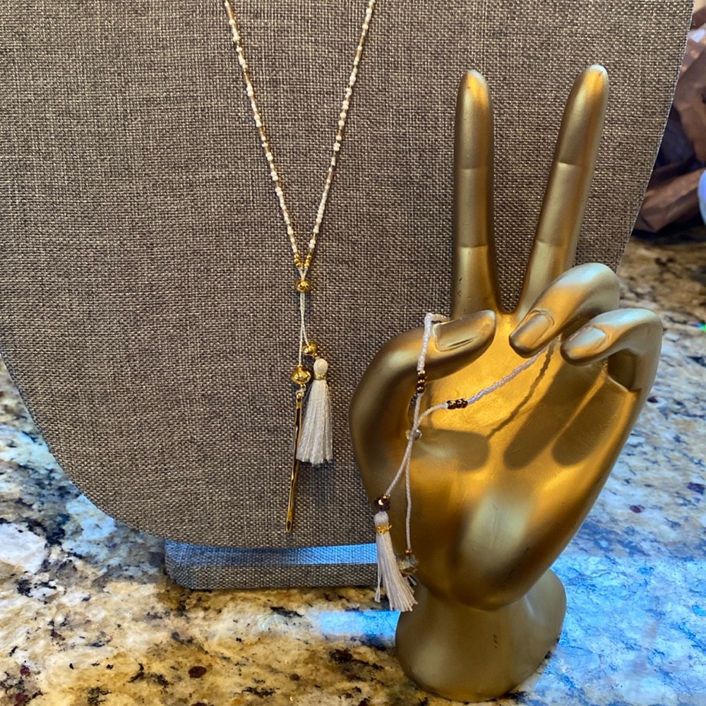 Gorjana long and dainty beaded necklace with white tassel and bracelet.